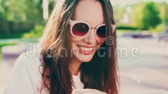 戴着太阳镜吹泡泡和在户外玩得开心的年轻女子的肖像电影慢镜头青年节视频的预览图