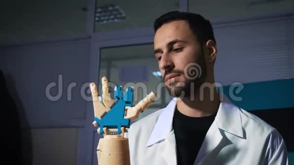 男性工程师科学家经历了机械手臂的仿生假体他看着机器人手的工作视频的预览图