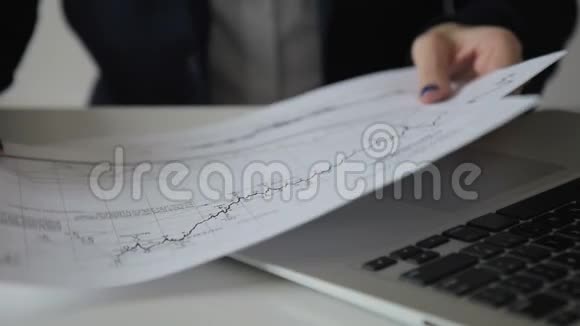 特写女人用笔在纸上的图表上做笔记视频的预览图