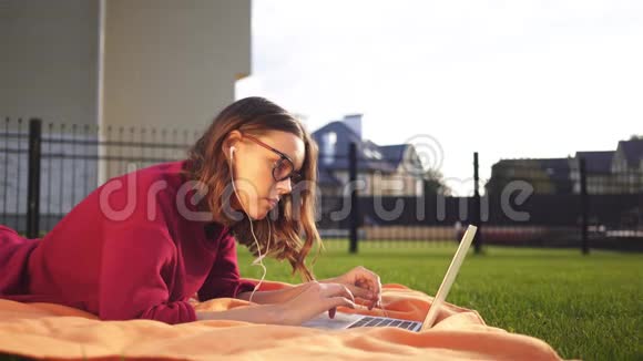 戴着眼镜的肥臀少女拿着笔记本躺在后院视频的预览图