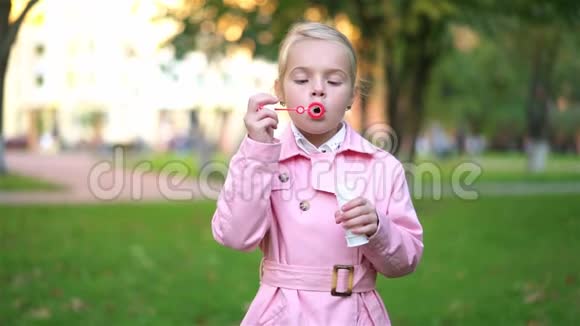 可爱的粉色小女孩在外面玩肥皂泡视频的预览图