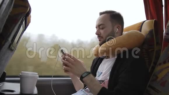 有枕头的人选择音乐在公共汽车旅行中听视频的预览图