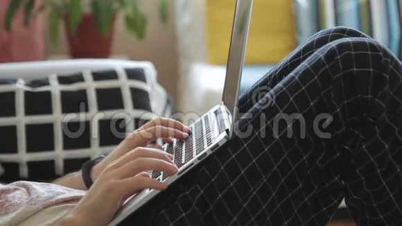 在房间里沙发上躺着笔记本电脑的年轻人视频的预览图