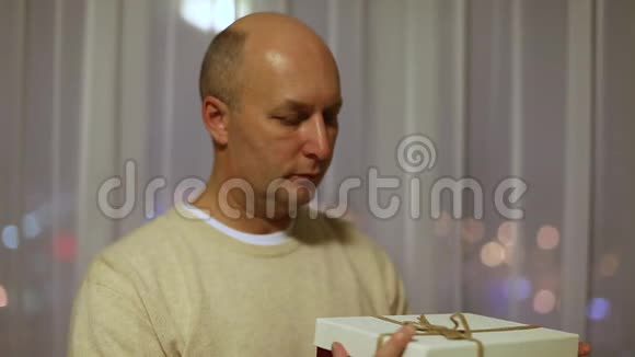 成人白种人男子打开礼品盒和惊喜一个惊喜的人看着盒子里的礼物视频的预览图