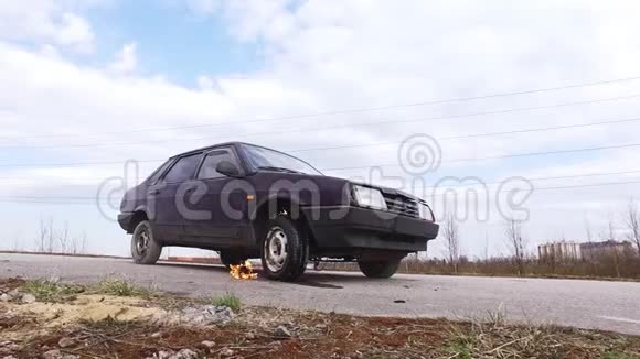 旧的生锈的紫罗兰色汽车在寒冷的日子里被遗弃在一条燃烧的车轮上视频的预览图