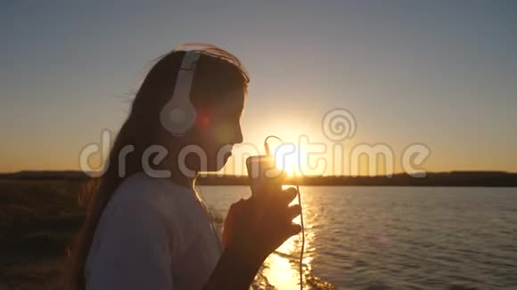 带着耳机的少女日落慢动作视频的预览图