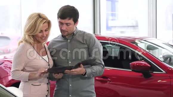 成熟夫妇在汽车经销商购买新汽车的小册子视频的预览图