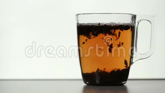 透明杯中茶叶的落叶视频的预览图