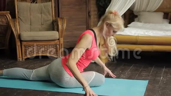 成熟的金发女士正在老式卧室里做瑜伽练习视频的预览图