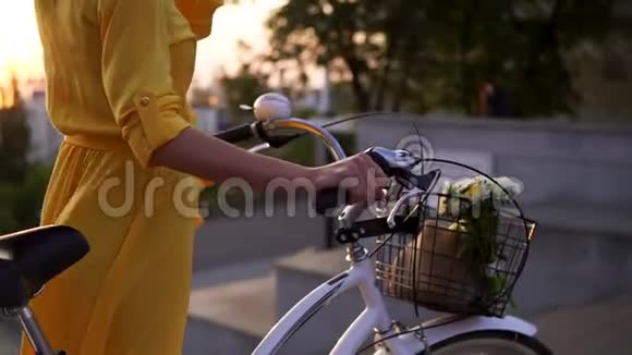 一个面目全非的女人的特写镜头她手里拿着一个自行车把手手里拿着一个篮子里面有漂亮的花和视频的预览图