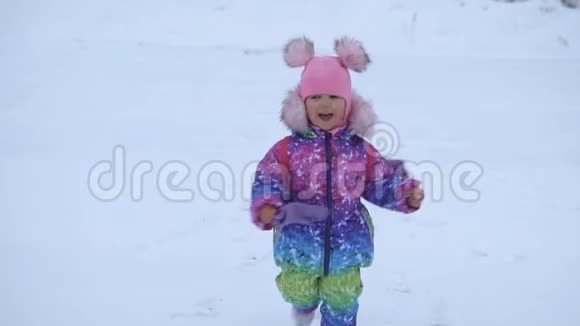 快乐可爱的小女孩在雪地里奔跑视频的预览图