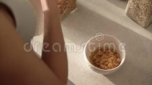 健康的早餐女人手把牛奶倒在碗里视频的预览图