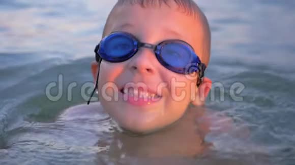 戴着护目镜微笑的孩子在海里游泳视频的预览图