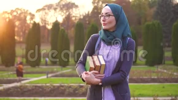 日落时公园里戴头巾的穆斯林学生视频的预览图