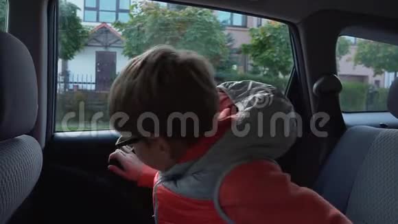 小学生上学男孩下车向父母挥手视频的预览图