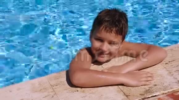 微笑的男孩在游泳池里放松视频的预览图