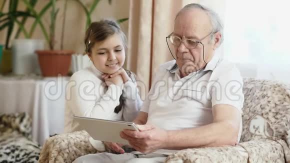 祖父用数字平板电脑带孙子视频的预览图