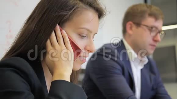女员工正在打电话坐在办公室同事旁边视频的预览图