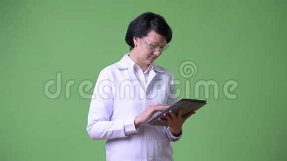 戴防护眼镜使用数码平板电脑的漂亮女医生视频的预览图