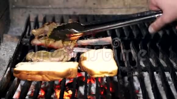 厨师把一块肉放在烤架上一块新鲜多汁的猪肉在煤上烤在烤架上煮肉视频的预览图