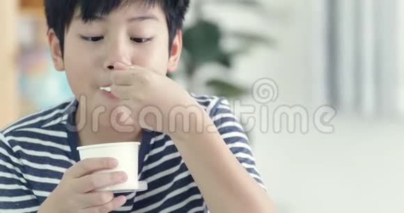 快乐的亚洲青少年男孩喜欢吃冰淇淋和微笑的脸视频的预览图