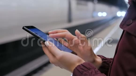 在地铁平台上使用智能手机的女人视频的预览图