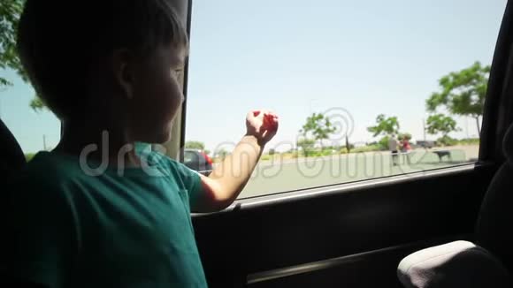 小男孩透过开着的车窗看着车视频的预览图