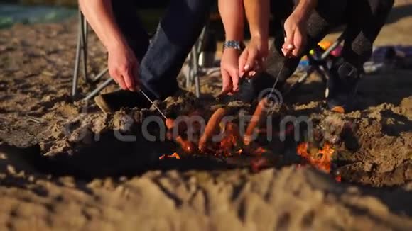 近距离拍摄人的手和身体他们在木桩上煮肉香肠视频的预览图