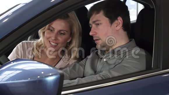 丈夫和妻子坐在一辆新车里在经销商的内部检查视频的预览图