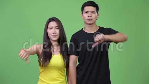 年轻愤怒的亚洲夫妇一起竖起大拇指视频的预览图