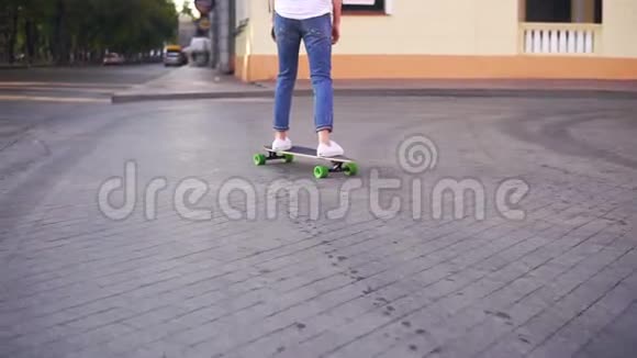 城市街上一个穿着白色t恤蓝色牛仔裤和白色运动鞋的女人的后景相机移动视频的预览图