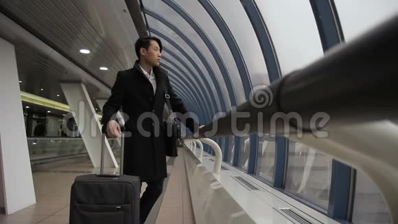 韩国亚洲人看着窗外然后沿着机场大楼走视频的预览图