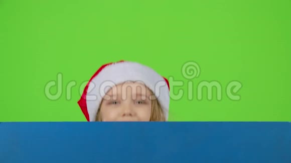 孩子从蓝色的木板后面往外看眨了眨眼绿色屏幕慢动作视频的预览图
