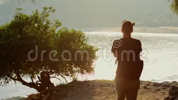 一个旅行者拍摄了一个美丽的日落在一个山湖的岸边的视频片段视频的预览图