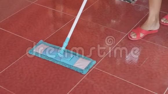 女性清洁红色瓷砖地板蓝色微纤拖把视频的预览图