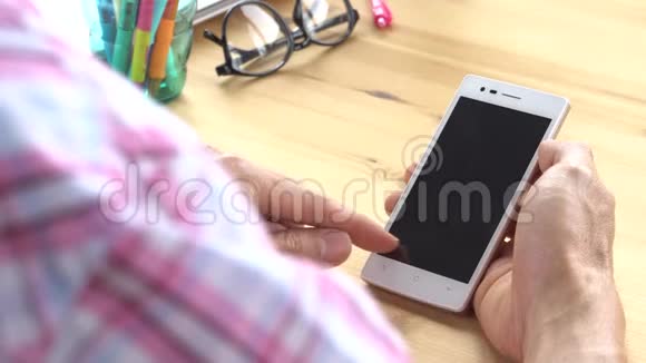 商务人员穿着粉色司各特衬衫在家庭办公室里使用变焦触摸智能手机视频的预览图