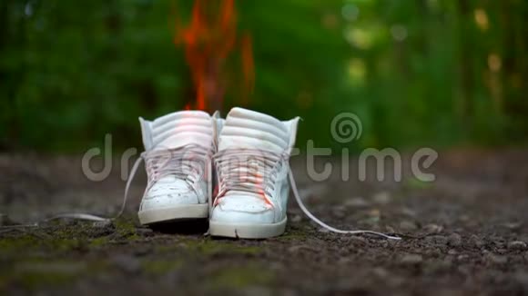 用白色高球鞋在森林里的乡村道路上燃烧视频的预览图