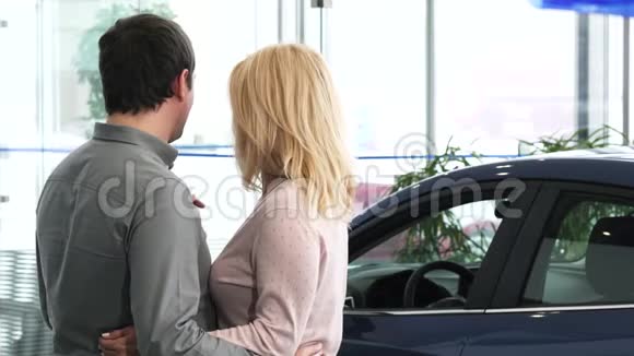 一对成熟夫妇在经销商处检查一辆新车的照片视频的预览图