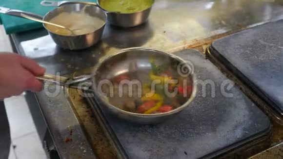 炒锅里放着蔬菜的肉厨师用炒锅里放着蔬菜来防止和扔牛肉视频的预览图