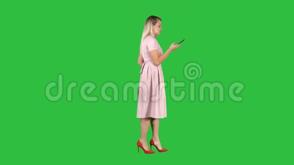穿着粉红色裙子的女人在绿色屏幕上打电话铬钥匙视频的预览图
