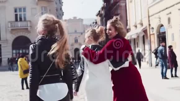 在市中心散步的三个健康的女人的后景然后转向相机开心地笑着伤亡视频的预览图