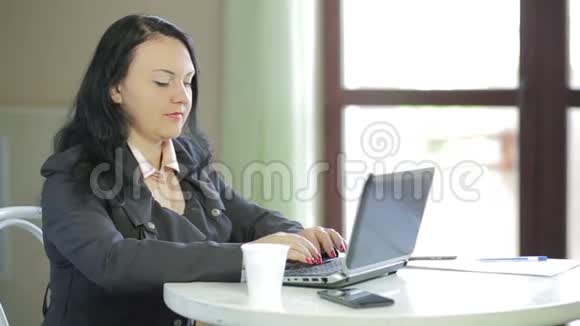 女商人在咖啡馆里用笔记本电脑工作从右到左的全景视频的预览图