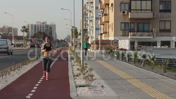 积极运动的年轻女性跑步用耳机听音乐医疗保健视频的预览图