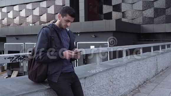 年轻英俊的阿拉伯男子在城市使用智能手机视频的预览图