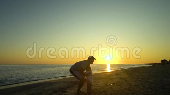 日落时一个年轻英俊的男人和他的小女儿沿着海滨散步爸爸把女儿抱在怀里视频的预览图