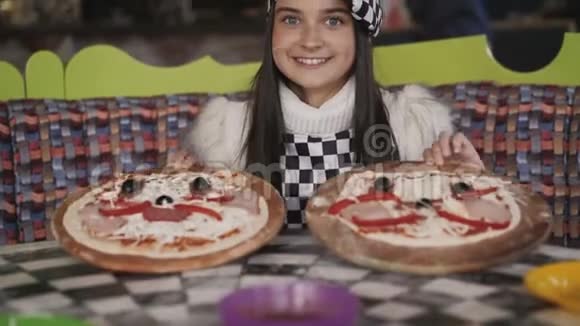 那个年轻女孩在镜头前展示了两个比萨饼4K视频的预览图