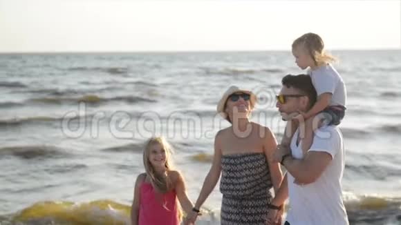 在海滨避暑时一家人一起在海滩上散步的肖像坚强的父亲视频的预览图