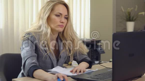 疲惫的女商人在办公室的工作场所睡着了视频的预览图