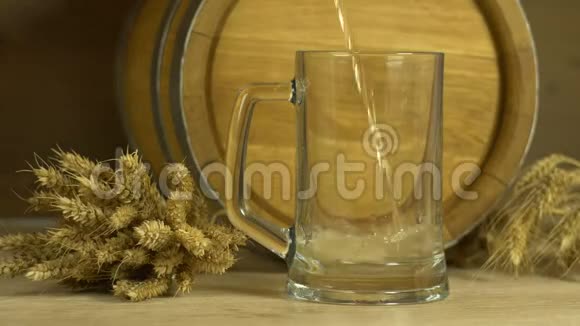 啤酒倒在玻璃杯里杯中装着桶和一堆小麦视频的预览图