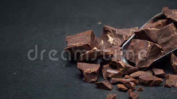 深色混凝土背景下的金属铲子上的黑巧克力块视频的预览图
